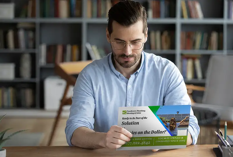 Man holding an EDDM postcard from a local solar company